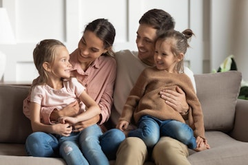Happy healthy family sitting on sofa at home