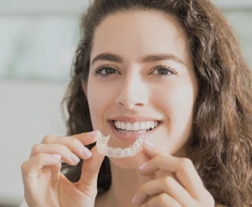 Woman holding clear aligner